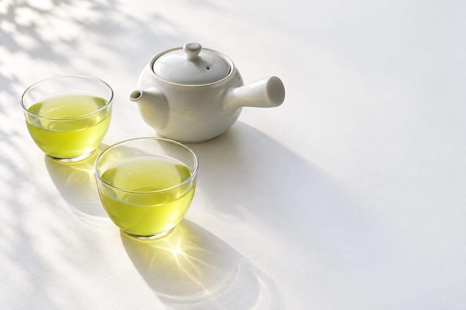 白いテーブルに白い急須と、煎茶の入ったガラスの湯呑みが2つ